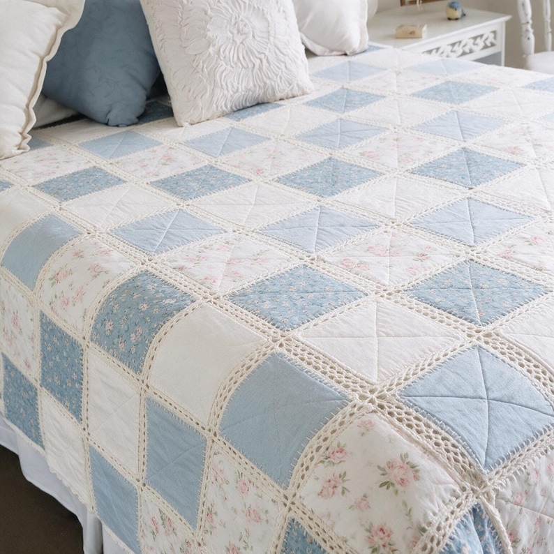 Pu&ograve; includere: Una trapunta patchwork con un motivo ripetitivo di quadrati azzurri a tinta unita, quadrati bianchi e quadrati con stampa floreale rosa. Ogni quadrato &egrave; unito da un bordo all'uncinetto color crema, il tutto drappeggiato su un letto.