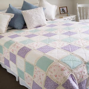 Pu&ograve; includere: Una trapunta patchwork con un motivo a rombi ripetuto di quadrati di tessuto color viola chiaro, verde menta e bianco a fiori. Ogni quadrato &egrave; unito da un bordo in pizzo all'uncinetto color crema, creando una griglia strutturata.