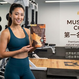 May include: A woman in teal athletic wear holds a bag of RYSE Mushroom Coffee in a gym setting. The bag features a sunflower design. Text on the wall reads "Mushroom Coffee" and "Premium organic blend with natural ingredients, smooth rich taste, enhanced focus and energy."