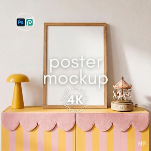 Op de afbeelding: Een verticale rechthoekige posterlijst met een lichthouten afwerking, geplaatst op een geel en roze gestreept kastje met een geschulpte rand. Links staat een gele paddenstoelvormige lamp en rechts een kleine carrousel-muziekdoos.