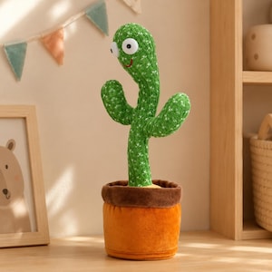 May include: A plush cactus toy with a green knitted texture, two arms, and large white plastic eyes. The cactus has a stitched red smile and is planted in a soft, brown, and orange fabric pot. The toy stands upright with a curved neck.