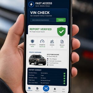 May include: A smartphone displaying a vehicle history report app with a dark blue interface. The screen shows a VIN check for a 2012 Ford Escape, indicating no major issues, 128,540 miles, two owners, and a clean history summary with green checkmarks.