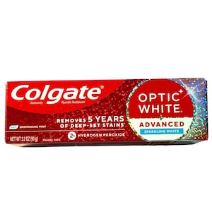 Peut inclure: Une boîte rouge et argentée de dentifrice Colgate Optic White Advanced. La boîte présente le logo Colgate, des informations sur le produit et les mots "Optic White" dans un cercle blanc. Contient 90 g de dentifrice.