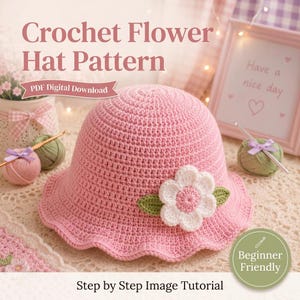 Op de afbeelding: Een roze gehaakte hoed met een witte en groene bloem. De hoed heeft een geschulpte rand en wordt getoond met garen en een haaknaald. Tekst op de afbeelding luidt "Crochet Flower Hat Pattern" en "Beginner Friendly".