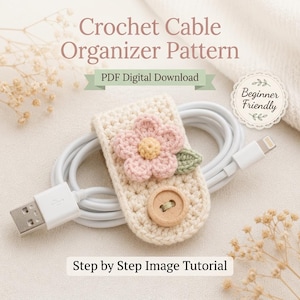 May include: A crocheted cable organizer pattern with a floral design. The beige organizer features a pink and yellow flower, a green leaf, and a wooden button. The text reads "Crochet Cable Organizer Pattern" and "PDF Digital Download".