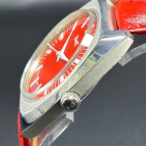 Puede incluir: Un reloj de pulsera con una esfera de color rojo vibrante y una caja de metal plateado pulido. El reloj cuenta con una correa de cuero rojo brillante y una peque&ntilde;a corona en el lateral grabada con la letra P. La esfera muestra el nombre Piaget en blanco.