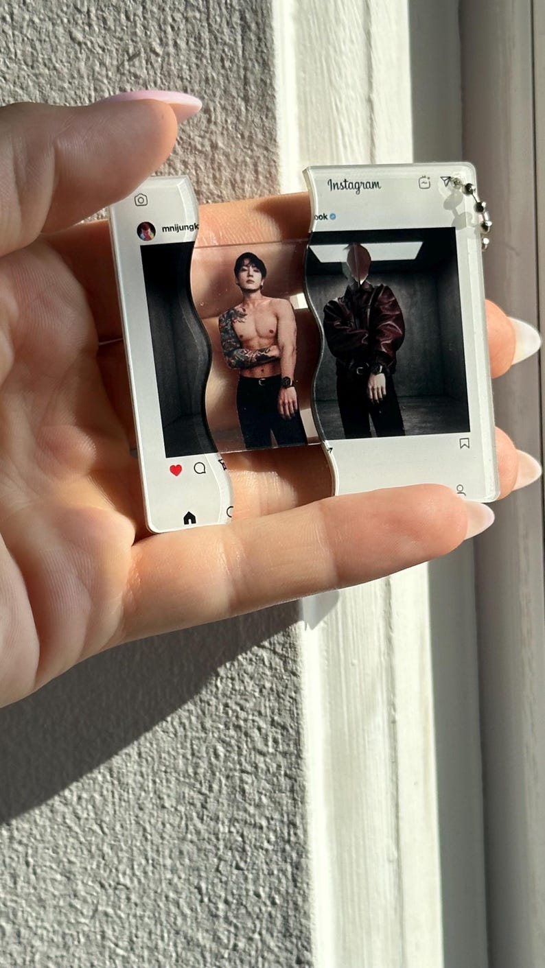 May include: A clear acrylic keychain shaped like two interlocking Instagram post frames. The left frame shows a shirtless person with tattoos, while the right frame displays a person in a dark jacket. Both frames feature the Instagram interface.
