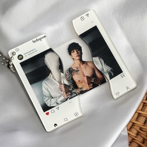 May include: A clear acrylic pendant with a photo of a person on an Instagram-style frame. The pendant has a silver chain. The photo shows a person with tattoos and a white shirt. The Instagram frame has the Instagram logo and icons.
