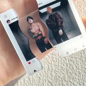 May include: A clear acrylic keychain shaped like two interlocking Instagram post frames. The left piece shows a profile icon with the text mnijungk, while the right piece displays the Instagram logo. The center features a split image of a person.