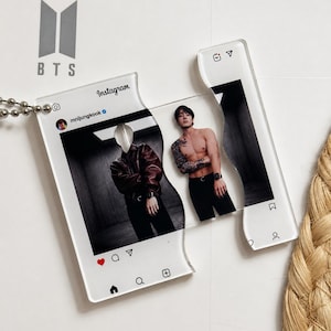 May include: A clear acrylic keychain shaped like an Instagram post featuring the handle mnijungkook. The design is split into two interlocking pieces, displaying a photograph of a person in a leather jacket and a shirtless person with tattoos.
