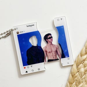 May include: A clear acrylic keychain designed as a split Instagram post featuring the username rkive. The left piece shows a silhouette against a blue background, while the right piece displays a shirtless person wearing sunglasses.