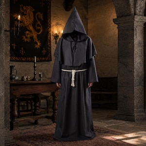 May include: A floor-length dark gray hooded robe featuring long, wide sleeves and a shoulder capelet. The garment is cinched at the waist with a thick, off-white knotted rope belt that hangs down the front, creating a structured, full-length silhouette.