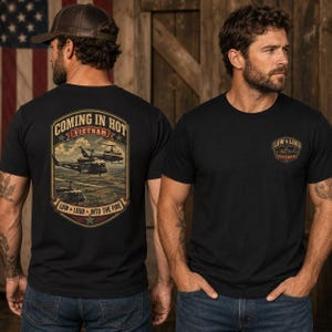 May include: A black t-shirt featuring a graphic on the back with military helicopters and the text Coming In Hot Vietnam Low Loud Into The Fire. The front chest area displays a smaller emblem with the text Low Loud Vietnam.