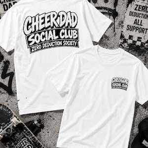 May include: White t-shirts with the text "CHEER DAD SOCIAL CLUB ZERO DEDUCTION SOCIETY" in black. One shirt has the text on the back, the other on the front. A skateboard and a black cap are in the image.