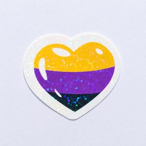 May include: A heart-shaped sticker featuring a horizontal tricolor design of yellow, purple, and black. The sticker has a holographic finish that creates a sparkling, reflective effect across the surface, with a white border surrounding the heart.