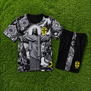 Könnte beinhalten: Ein schwarz-weißes Grafik-T-Shirt und Shorts-Set. Das T-Shirt zeigt ein Bild von Christus dem Erlöser mit einem schwarzen Rundhalsausschnitt. Die Shorts sind schwarz mit einem dekorativen Seitenteil und einem gelb-grünen Emblem.