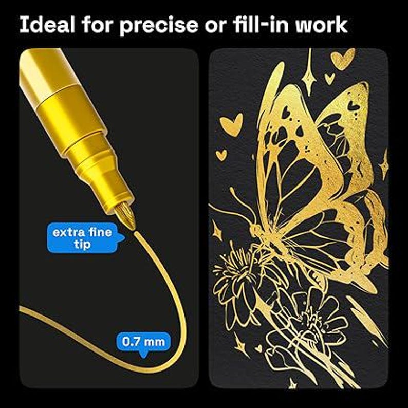 May include: A gold extra fine tip marker with a 0.7 mm tip is shown on a black background. The marker is creating a gold line. Next to it is a gold butterfly and flower design on a black background.