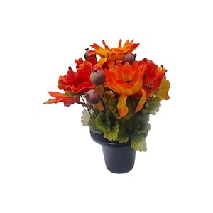 Arranjo floral de outono em vaso com flores artificiais em formato de abóbora para homenagem a túmulos, tributo no cemitério, decoração sazonal para sepulturas.