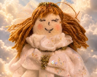 May include: A handcrafted angel ornament featuring a white felt face with stitched facial features, rosy cheeks, and brown yarn hair. The figure wears a white ruffled collar and a white dress adorned with iridescent glitter, accented by gold tinsel trim.
