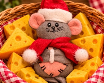 May include: A gray felt mouse ornament wearing a red and white Santa hat and a red scarf, positioned inside a woven basket filled with triangular yellow cheese wedges. The mouse has pink ears, a pink belly patch, and a gold wire heart topper.