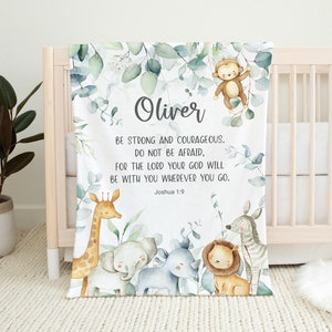 May include: A white baby blanket with a green leafy design and a watercolor illustration of animals. The blanket features the name "Oliver" and the Bible verse "Be strong and courageous. Do not be afraid, for the Lord your God will be with you wherever you go. Joshua 1:9."