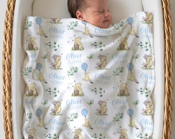 May include: A baby sleeps peacefully in a wicker bassinet, wrapped in a white blanket. The blanket features a repeating pattern of a cartoon bear, blue balloons, and green foliage. The name "Oliver THOMAS" is printed on the blanket.