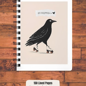 May include: A spiral-bound notebook with a glossy laminated cover featuring a black crow wearing white roller skates on a light beige background. The text "go anyway...." with a small heart is printed above the crow. It has 150 lined pages and measures 12.7 x 17.8 cm.