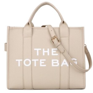 Pu&ograve; includere: Borsa tote beige con la scritta bianca "THE TOTE BAG". La borsa ha due manici superiori e una tracolla staccabile con fibbia color oro. La borsa &egrave; realizzata in un materiale strutturato.