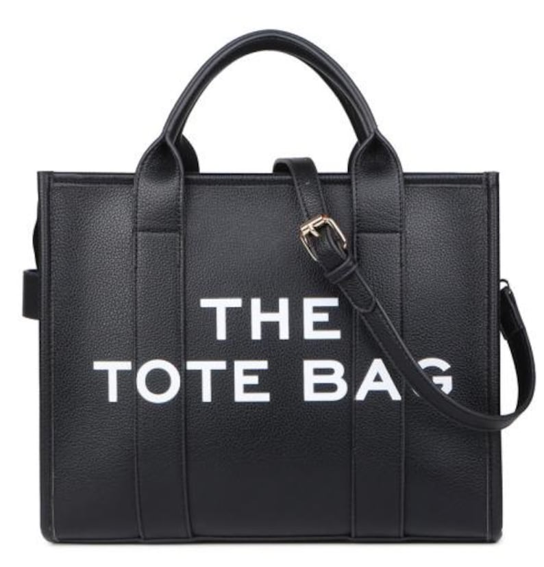 Pu&ograve; includere: Borsa tote nera con la scritta "THE TOTE BAG" in lettere bianche. La borsa ha due manici superiori e una tracolla staccabile con fibbia color oro. La borsa &egrave; realizzata in materiale strutturato.