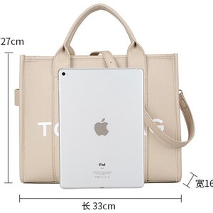 Pu&ograve; includere: Borsa tote beige con manico superiore e tracolla staccabile. La borsa &egrave; lunga 33 cm, alta 27 cm e larga 16 cm. Sulla borsa &egrave; stampata la scritta "TOG". Un iPad &egrave; posizionato davanti alla borsa.