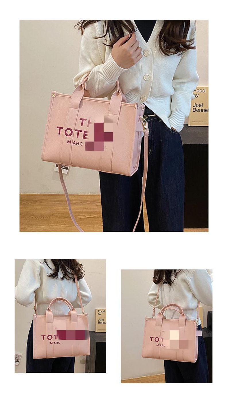 May include: A light pink tote bag with the words "TI TOTE MARC" printed on the front. The bag has a top handle and a detachable shoulder strap. The bag is made of a smooth material and has a rectangular shape.