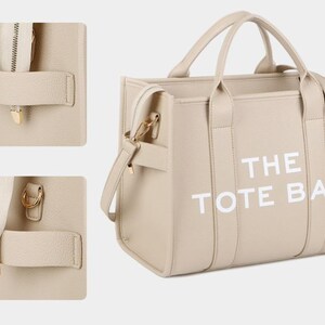 Pu&ograve; includere: Borsa tote beige con la scritta bianca "THE TOTE BAG". La borsa ha due manici e una tracolla staccabile. Dettagli: hardware color oro e chiusura con cerniera.