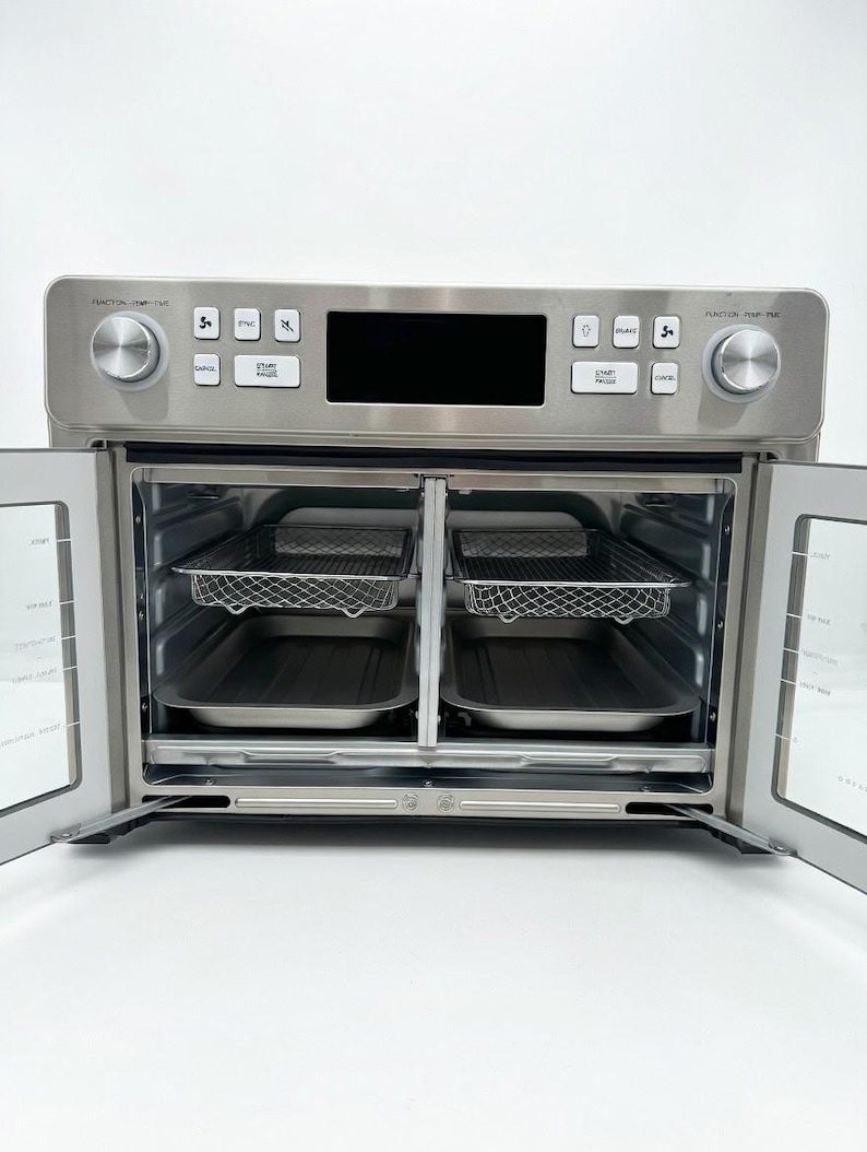 May include: A stainless steel air fryer oven with the doors open, revealing two wire racks and two trays. The control panel has a digital display and several buttons and dials. The oven is on a white surface.