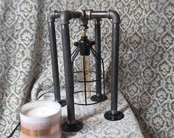 Pipe lamp with bulb cage and Edison bulb.