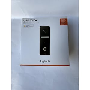 Może przedstawiać: Czarny dzwonek wideo Logitech Circle View w oryginalnym opakowaniu. Pudełko jest białe z nazwą produktu i logo. Dzwonek ma kamerę, światło i przycisk. Na pudełku jest również napisane, że współpracuje z Apple HomeKit.