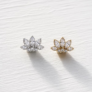 May include: Two stud earrings shaped like lotus flowers, one in silver-tone metal and one in gold-tone metal. Each earring features five marquise-cut clear stones arranged in a fan pattern above three small round clear stones at the base.