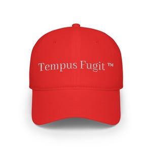 May include: A bright red baseball cap with a curved brim. The phrase "Tempus Fugit" is embroidered in white across the front. The hat is a classic six-panel design.