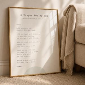 Può includere: Una stampa artistica incorniciata con il testo A Prayer for My Son in un carattere stile macchina da scrivere su sfondo color crema. La stampa presenta un grafico a semicerchio verde salvia tenue in basso ed è racchiusa in una cornice dorata.