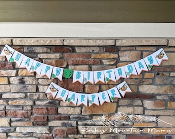 May include: A white banner set with the words "HAPPY BIRTHDAY HARPER" in blue letters. The banner features sloth and leaf illustrations. The banner is strung against a brick wall.