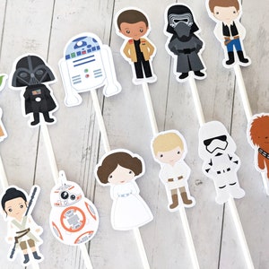 Puede incluir: Un conjunto de 11 adornos para tartas con personajes de Star Wars. Los adornos representan personajes como Yoda, Darth Vader, R2-D2, Chewbacca y un Stormtrooper. Los adornos est&aacute;n impresos en cartulina blanca y unidos a palos blancos.