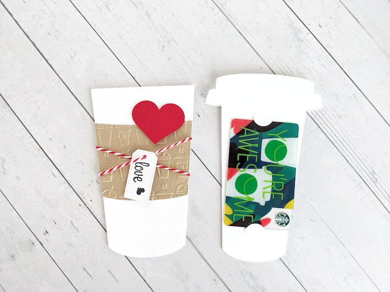Puede incluir: Dos vasos de papel blancos, uno con una manga de papel marr&oacute;n con dise&ntilde;os de vasos de caf&eacute; y un coraz&oacute;n rojo, y el otro con una tarjeta de regalo que dice "You're Awesome" en texto verde. El vaso con la tarjeta de regalo tiene una tapa blanca.
