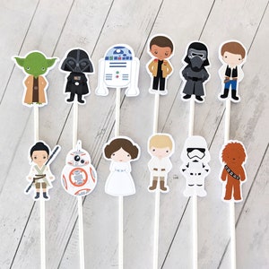 Puede incluir: Un conjunto de 10 adornos para tartas de personajes de Star Wars. Los adornos representan personajes como Yoda, Darth Vader, R2-D2, Han Solo, Chewbacca, la princesa Leia y un Stormtrooper. Los adornos est&aacute;n impresos en cartulina y unidos a palos de madera.