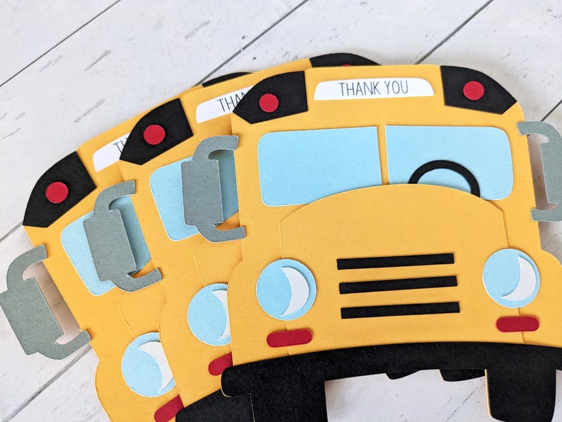 May include: Yellow school bus-shaped cards with black and red details. The cards feature light blue windows and grey side mirrors. Each card has the words "THANK YOU" printed at the top. The cards are arranged in a fan shape.