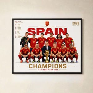 Puede incluir: Un póster enmarcado que muestra a la selección nacional de fútbol de España con camisetas rojas y el texto SPAIN, CHAMPIONS y FIFA WORLD CUP 2026. La imagen muestra a los jugadores y un entrenador posando con un trofeo dorado y una lista.