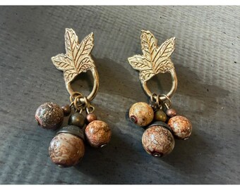 Brincos vintage dourados em formato de folha com pingente de contas marrons salpicadas, estilo boho.