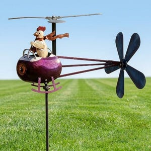 May include: A metal garden wind spinner shaped like a helicopter with a purple fuselage and a white chicken pilot wearing a brown scarf. The helicopter features a top rotor, a tail boom with a six-blade rear propeller, and landing skids.