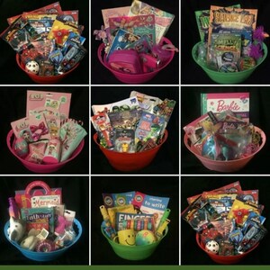 May include: Nine colorful gift baskets filled with toys, books, and accessories. Each basket is a different color, including red, pink, green, and blue. The baskets contain items like Barbie dolls, LOL Surprise items, and Spider-Man toys. Some baskets include a soccer ball.