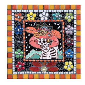 May include: A colorful mosaic tile featuring a skeleton wearing a pink flower-adorned hat. The tile is surrounded by a black and white mosaic border with a red, orange, and yellow outer border.