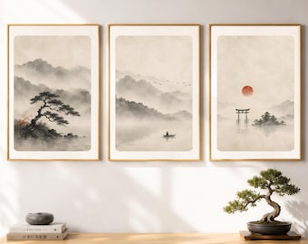 May include: A set of three framed wall art prints featuring ink-wash style landscapes in muted beige and gray tones. The prints depict misty mountains, a lone pine tree, a small boat on water, a flock of birds, a torii gate, and a red sun.