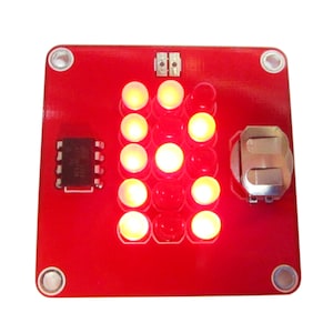 May include: A red circuit board with a 16-segment LED display. The display is showing the number 8. The board has a small chip and a battery holder.